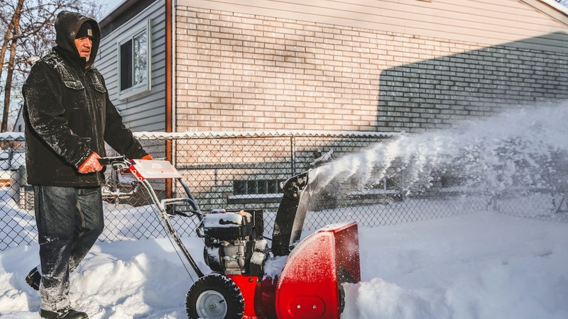Winterdienst: Schneeräumung mit Schneefräse vor einem Wohnhaus